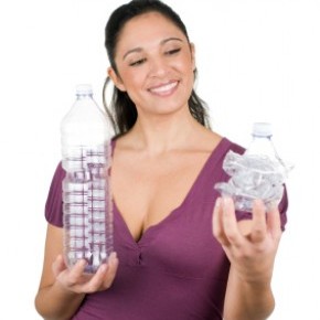 Frau mit einer wiederverwerteten Plastikflasche 